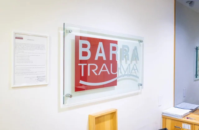 Placa com a marca Barra Trauma na parede da recepção