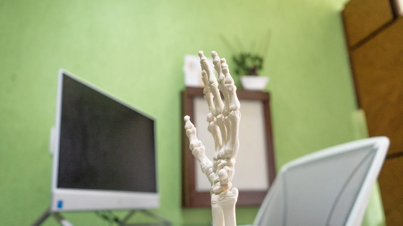 Modelo anatômico dos ossos da mão sobre a mesa do consultório da Barra Trauma