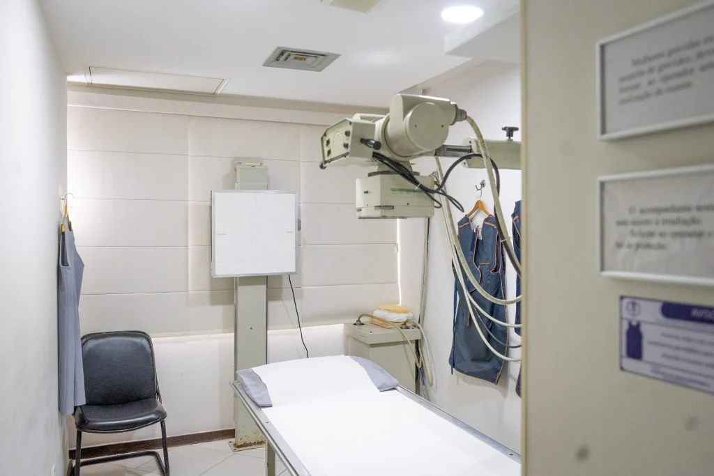 Sala de radiologia digital da Barra Trauma, com aparelho de raio-X e maca